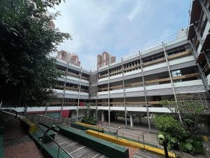 Accessible multi-storey building in Singapore with ramps, handrails and step-free pathways surrounded by greenery.