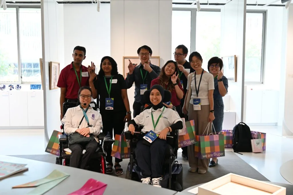Enabling Village tour guests with guides, including wheelchair users, smiling together